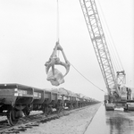 171033 Afbeelding van het vervoer van stenen per spoor ten behoeve van de aanleg van de Europoorthaven bij Rotterdam.